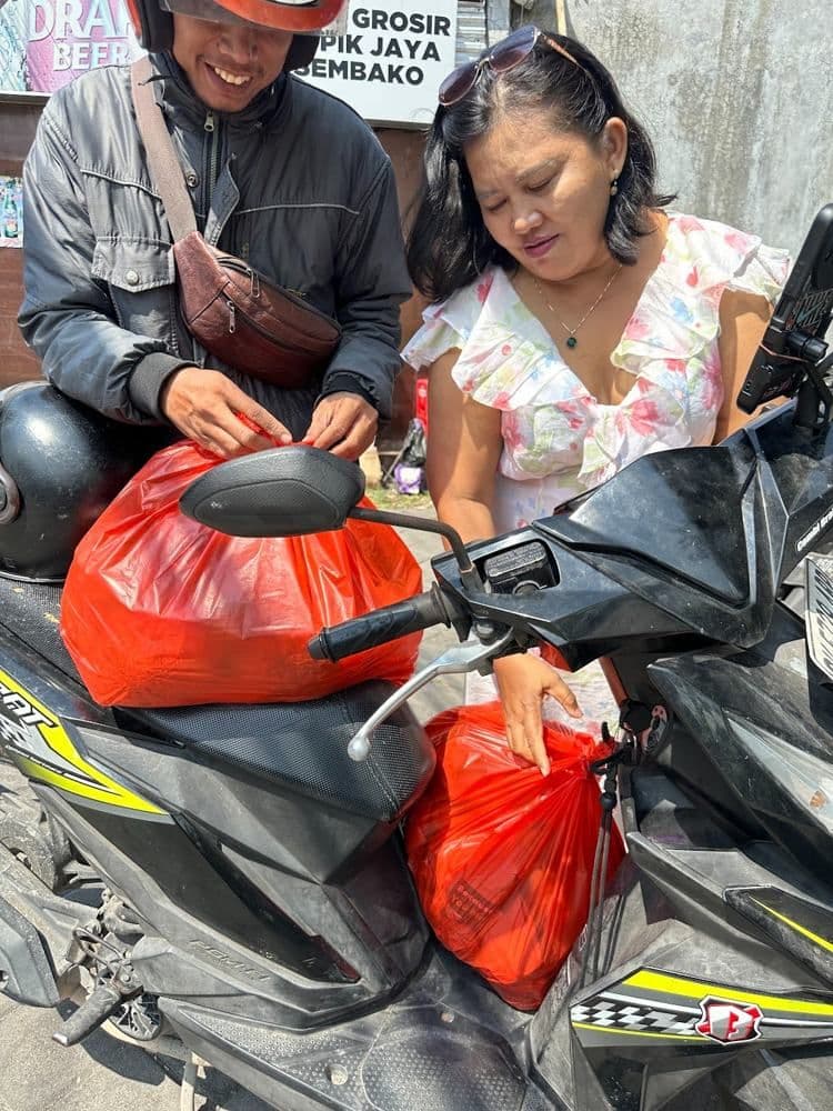 Handing meals to a waste collector at TPA Suwung