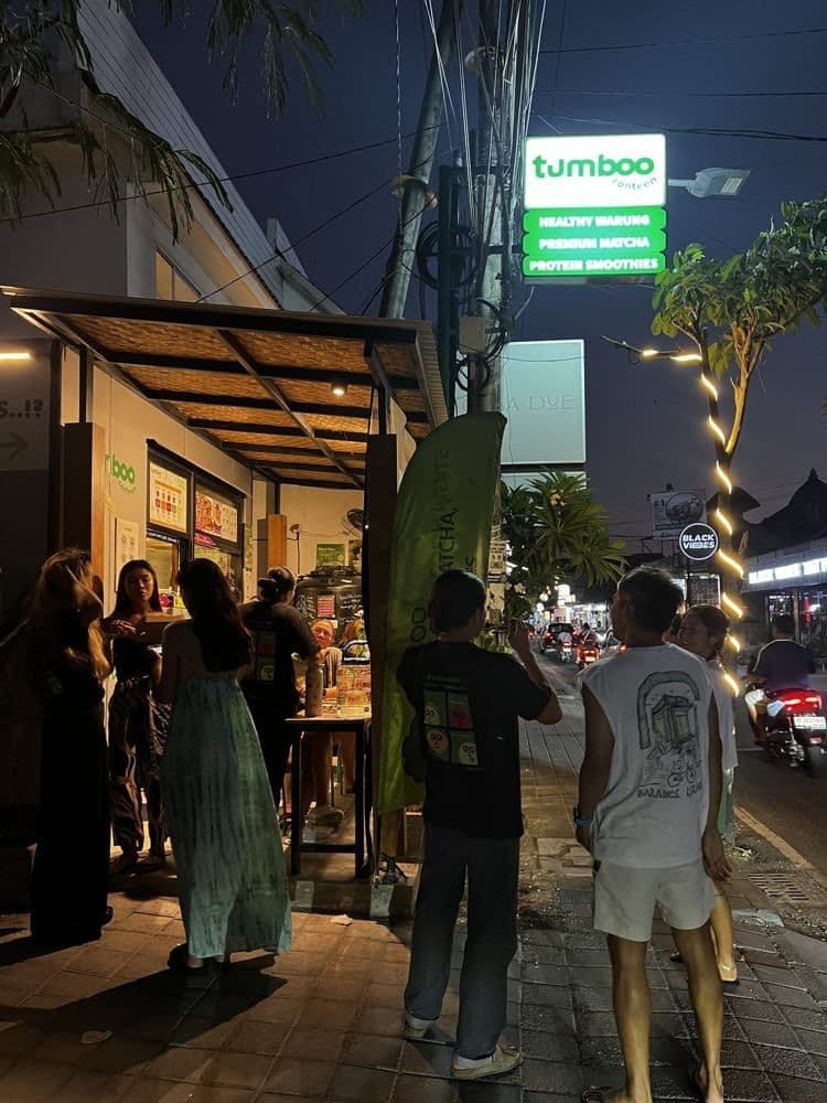 Batu Bolong shopfront at dusk with a crowd outside
