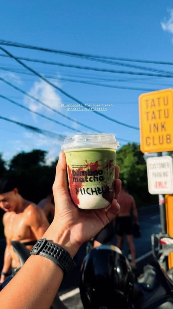 A Tumboo matcha cup held up against the sky